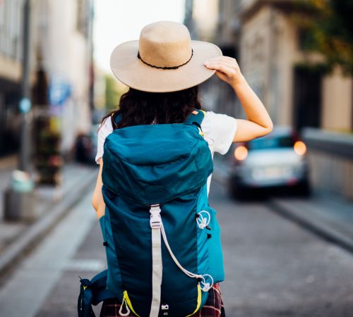 The tourist girl with a backpack is traveling